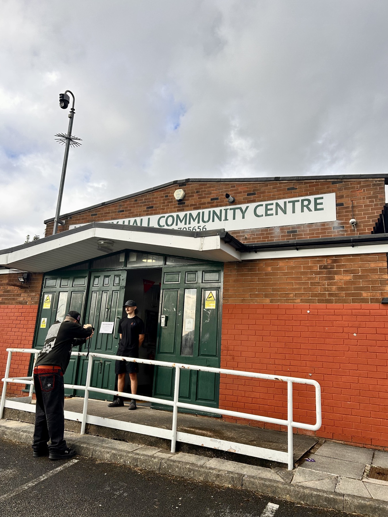 A portrait being photographed outside a community centre
